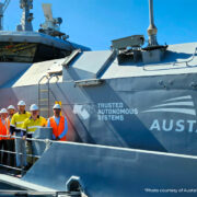 work men standing next to a large sea vessel